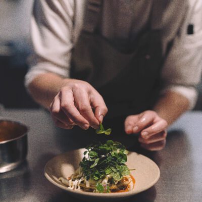 Szegediner Kraut mit Unkrautsalat und Holunderblüte auf Teller