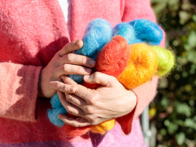 Frau mit bunter Wolle in den Händen