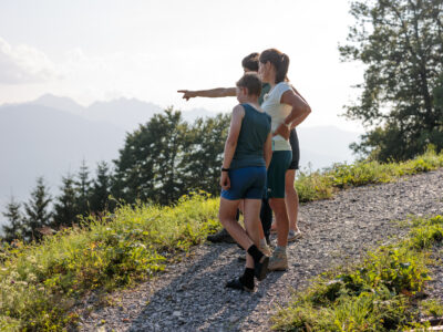 Drei Personen stehen in der Landschaft und Blicken in die Ferne. Ankündigungsbild für Bio-Stammtische Vorarlberg