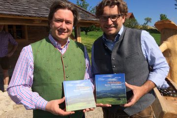 Männer präsentieren das Buch Die Bio-Heu-Region