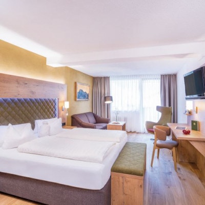 © Leutascherhof Innenansicht des Zimmers mit grauem Stoffbett und